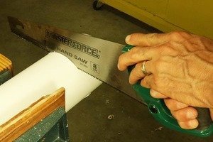 Cutting PVC with a hand saw.