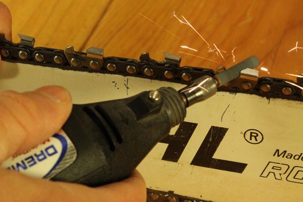 Sharpening a chain on a chainsaw.
