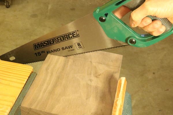 Cut tic-tac-toe board with hand saw.