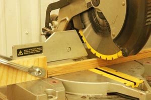 Using a miter saw to cut the wooden strips for the wind spinners.