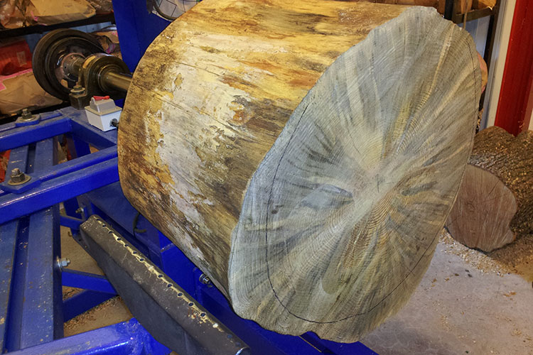 The pine log has been mounted on the lathe.